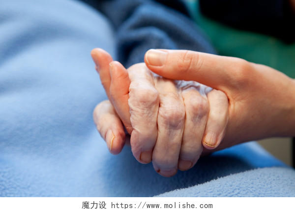 养老陪伴年轻的手和老皱的手握在一起合作